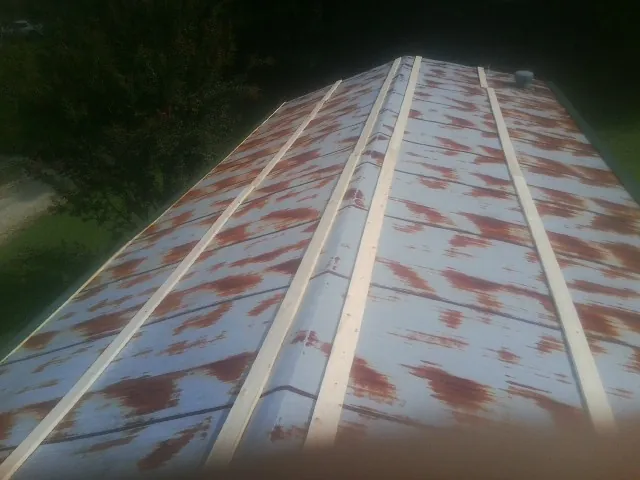 Rusted metal roof panels with new wood purlins before replacement — Storm Damage Roof Repair in Paeonian Springs by Roofing Brothers