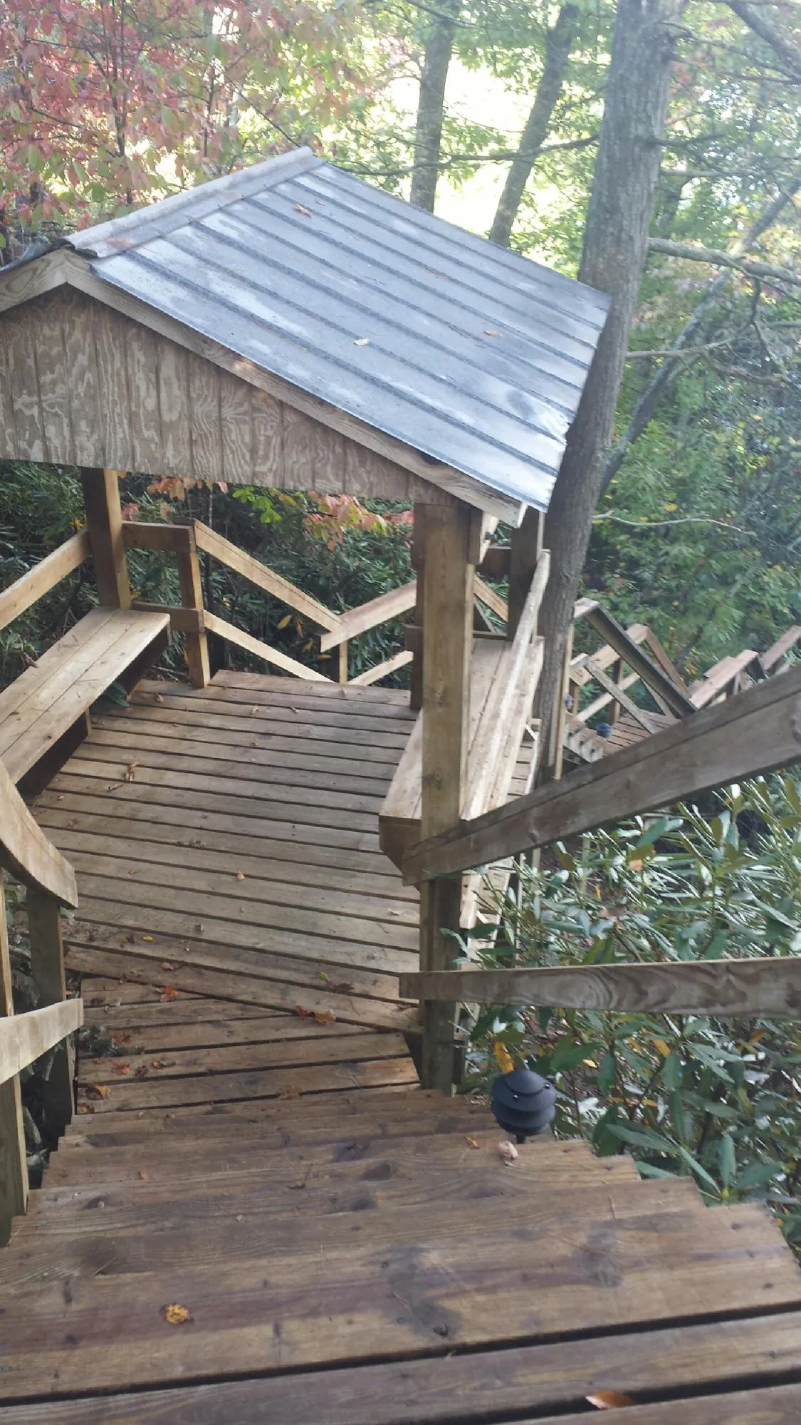 Metal roofed shelter over wooden steps on a wooded walkway — Skylight Repair & Installation work by our crew in Paeonian Springs