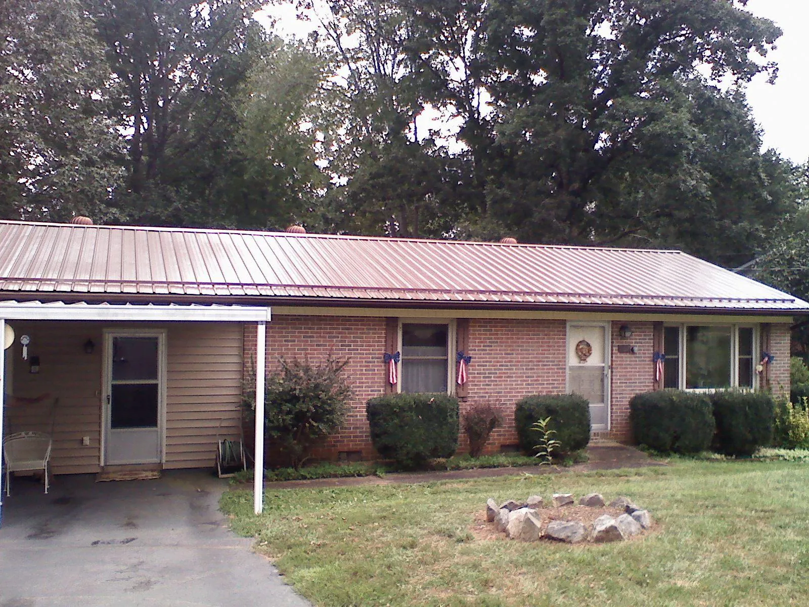 Bronze metal roof and carport on a brick ranch home — Roof Repair work by our crew in Paeonian Springs